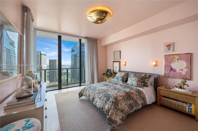 bedroom featuring expansive windows, access to outside, and a view of city