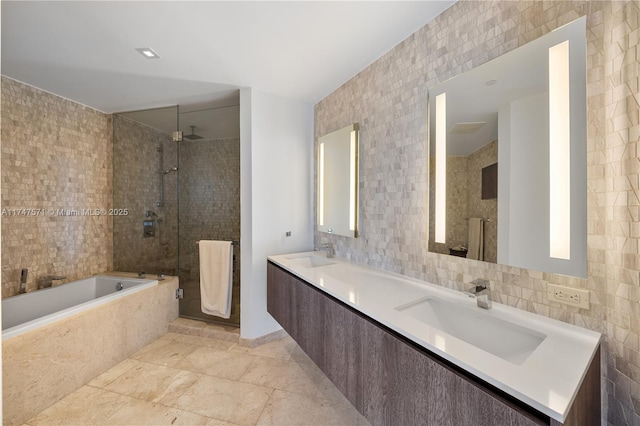 full bathroom with a sink, tile walls, and a shower stall