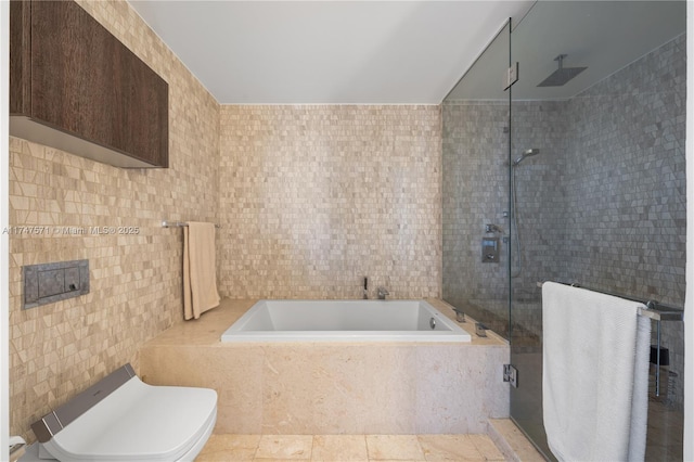 full bath featuring a garden tub, a tile shower, tile walls, and tile patterned floors