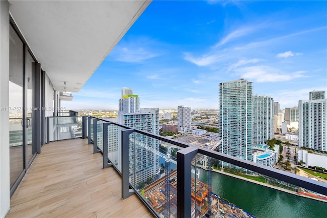 balcony with a water view and a view of city