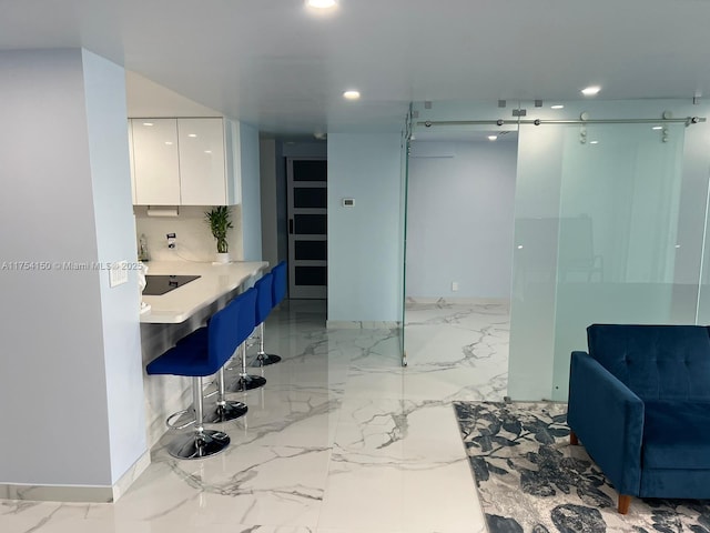 kitchen with marble finish floor, modern cabinets, white cabinetry, and recessed lighting