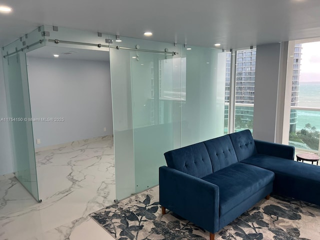 interior space with marble finish floor, a barn door, and recessed lighting