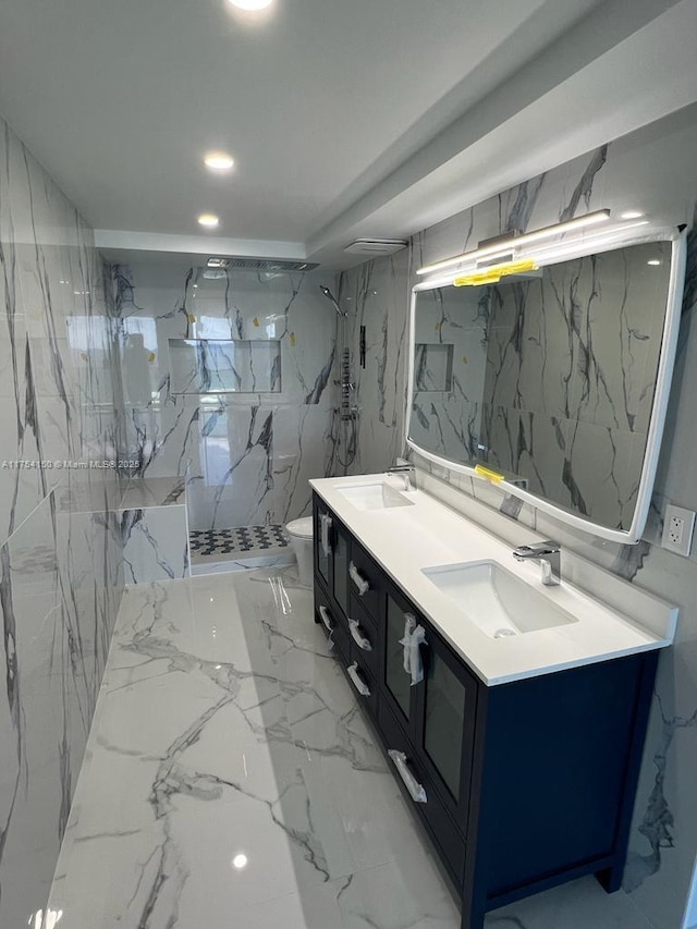 bathroom with toilet, stone wall, double vanity, and a sink