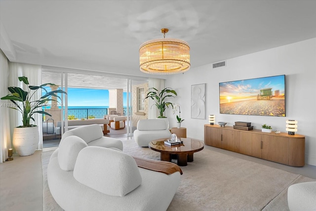 living area featuring visible vents and a notable chandelier