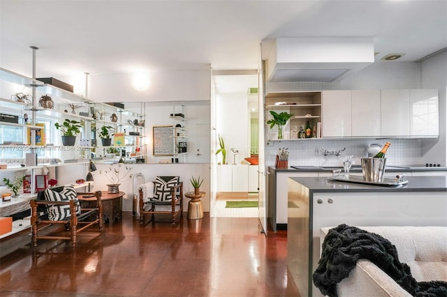 kitchen featuring dark countertops, decorative backsplash, white cabinetry, and open shelves