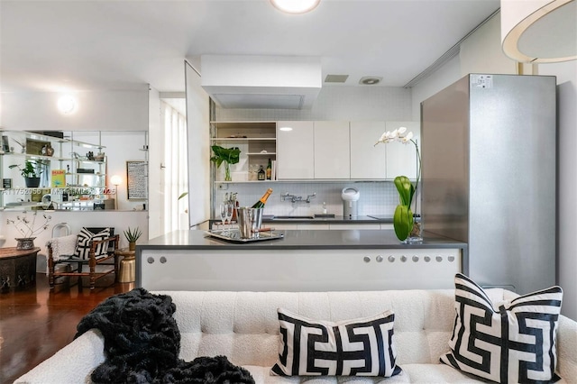 kitchen with white cabinets, backsplash, dark wood-style floors, open shelves, and dark countertops