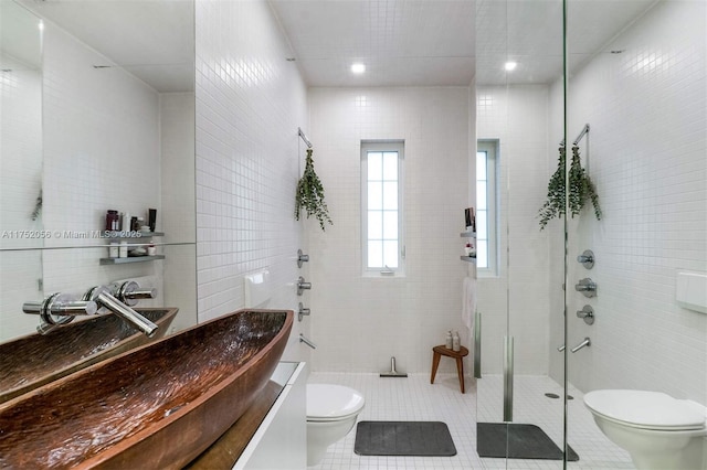 full bathroom featuring tiled shower, toilet, tile patterned flooring, vanity, and tile walls