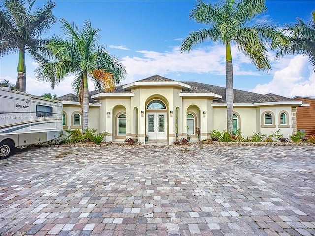 mediterranean / spanish-style home with french doors and stucco siding