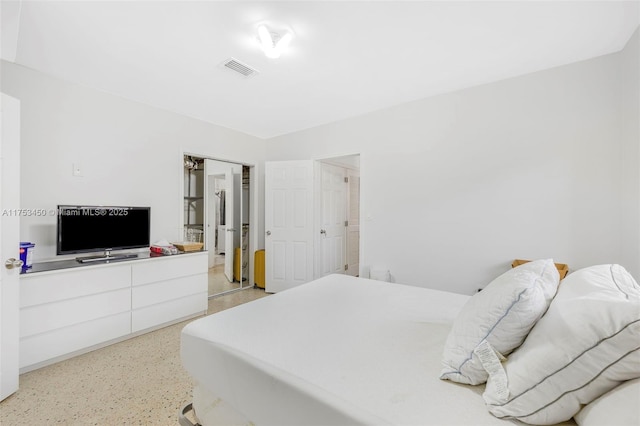 bedroom with light speckled floor and visible vents