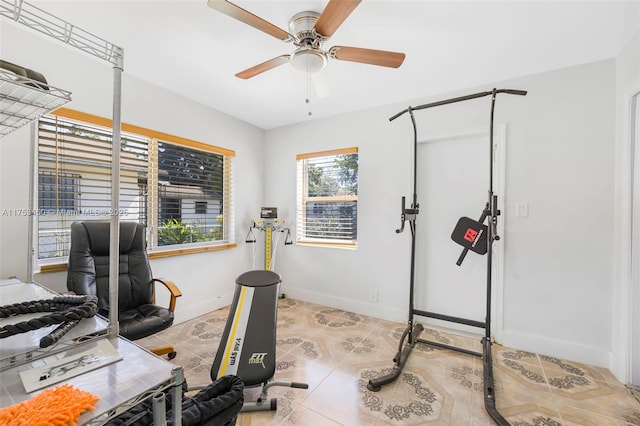 workout room with ceiling fan, light tile patterned floors, and baseboards