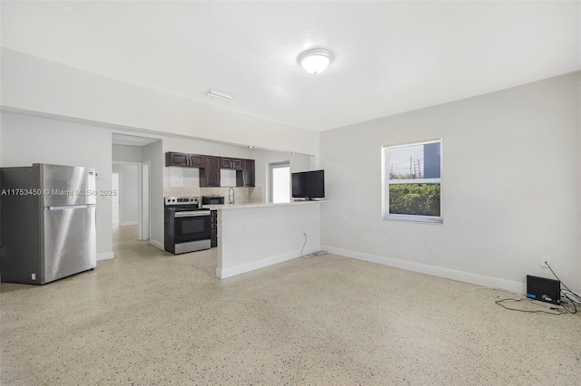 kitchen featuring stainless steel appliances, a wealth of natural light, light countertops, and dark brown cabinetry