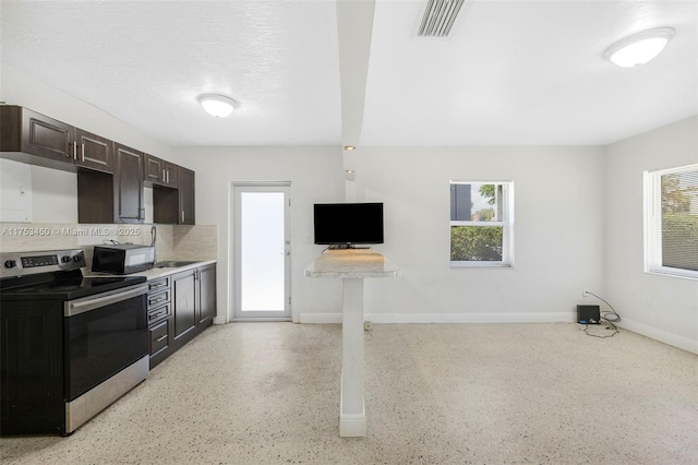 kitchen featuring dark brown cabinetry, baseboards, stainless steel electric stove, a textured ceiling, and light speckled floor