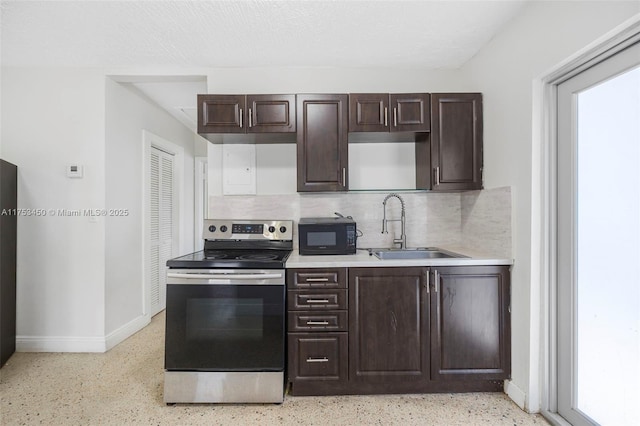 kitchen featuring dark brown cabinetry, stainless steel electric range, black microwave, light speckled floor, and a sink