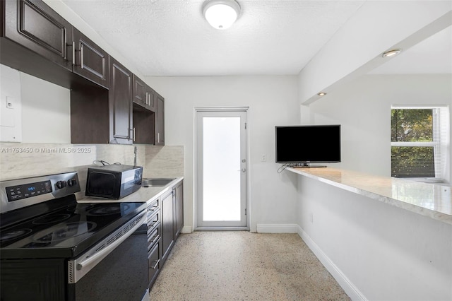 kitchen featuring light countertops, dark brown cabinets, a textured ceiling, and stainless steel electric range