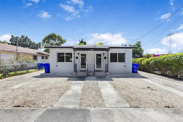 bungalow-style house featuring fence and stucco siding