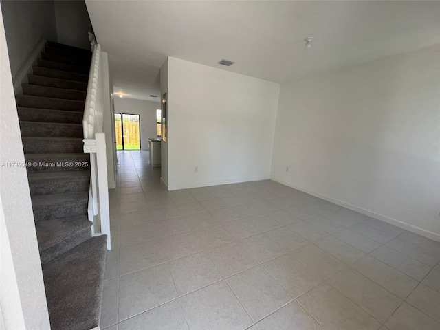 spare room featuring visible vents, stairway, baseboards, and light tile patterned flooring