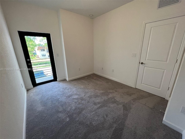 carpeted empty room featuring visible vents and baseboards