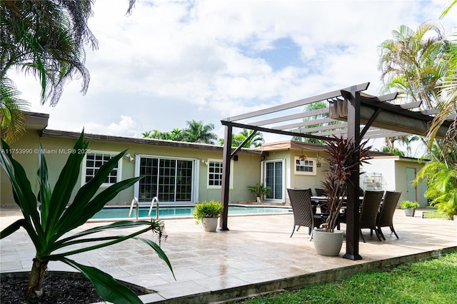 back of property with stucco siding, an outdoor pool, a pergola, and a patio