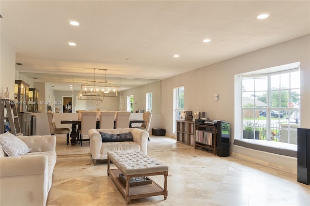 living room with recessed lighting and an inviting chandelier