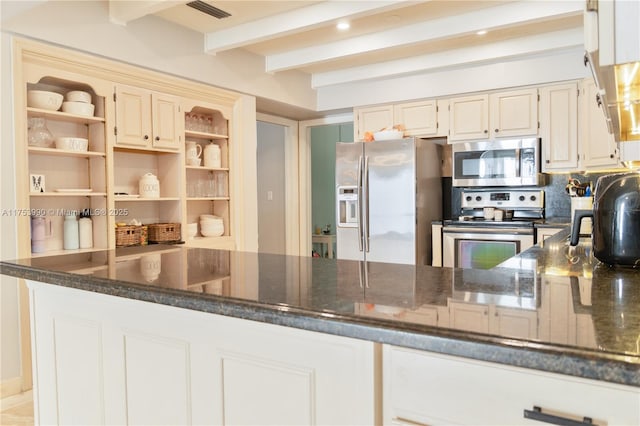 kitchen with appliances with stainless steel finishes, visible vents, beamed ceiling, and dark stone countertops