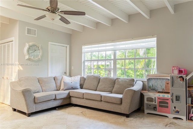 living room featuring a ceiling fan, visible vents, plenty of natural light, and beamed ceiling