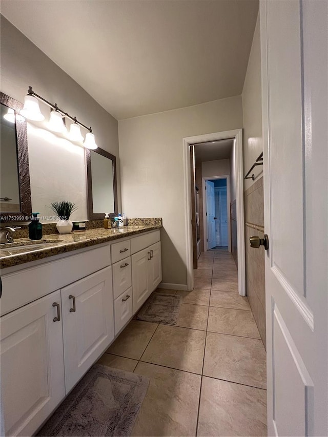 full bath with double vanity, tile patterned flooring, and a sink