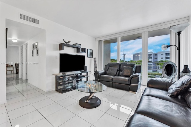 living area featuring a wall of windows, visible vents, and light tile patterned floors