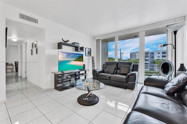 living room with floor to ceiling windows, visible vents, and tile patterned floors