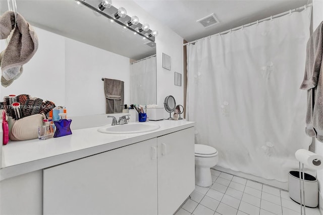 bathroom featuring toilet, vanity, visible vents, and tile patterned floors