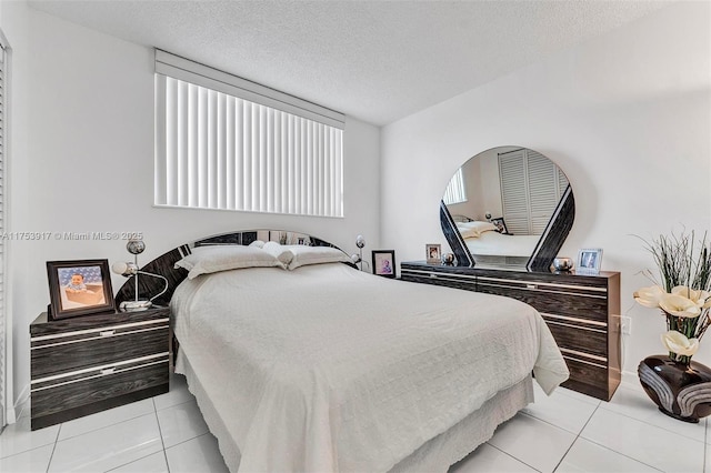 bedroom with light tile patterned flooring and a textured ceiling