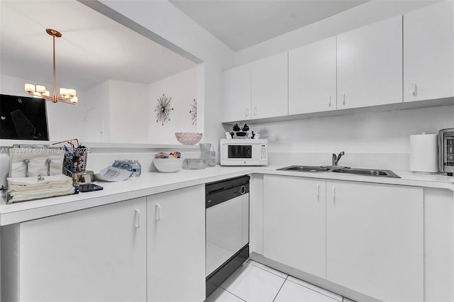 kitchen with dishwasher, white microwave, light countertops, white cabinetry, and a sink