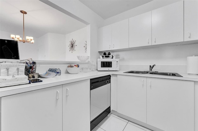 kitchen featuring light countertops, white microwave, white cabinets, a sink, and dishwasher