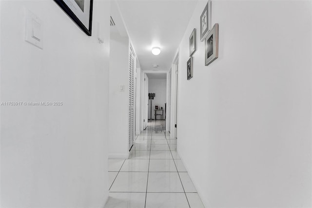 hall with light tile patterned floors and baseboards