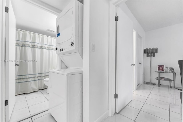 washroom with laundry area, light tile patterned flooring, and stacked washing maching and dryer