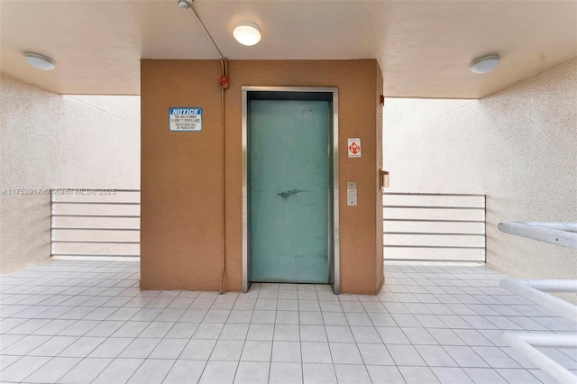 view of exterior entry featuring elevator and stucco siding