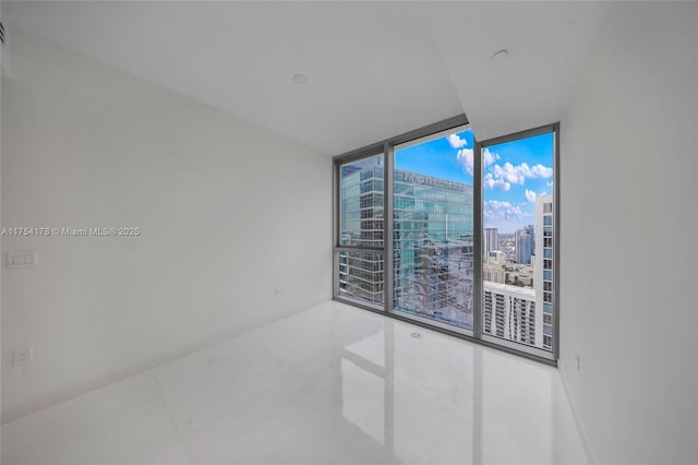 empty room featuring a city view and floor to ceiling windows