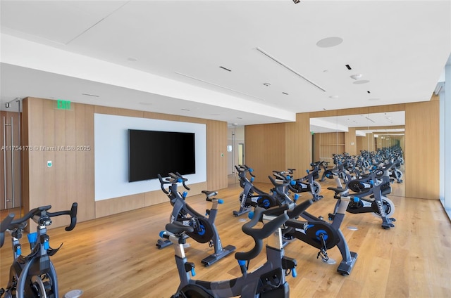 workout area featuring wooden walls and wood finished floors