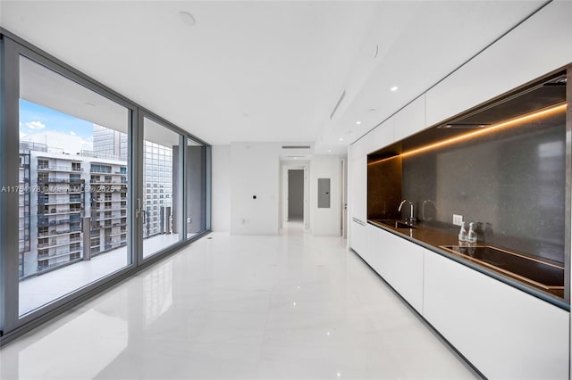 kitchen with a sink, white cabinets, backsplash, dark countertops, and modern cabinets