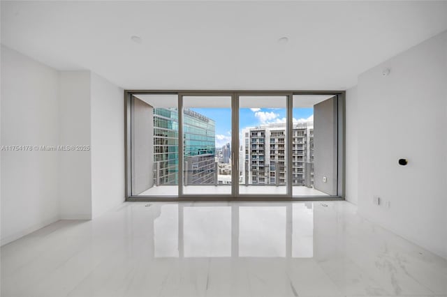 empty room featuring marble finish floor and floor to ceiling windows