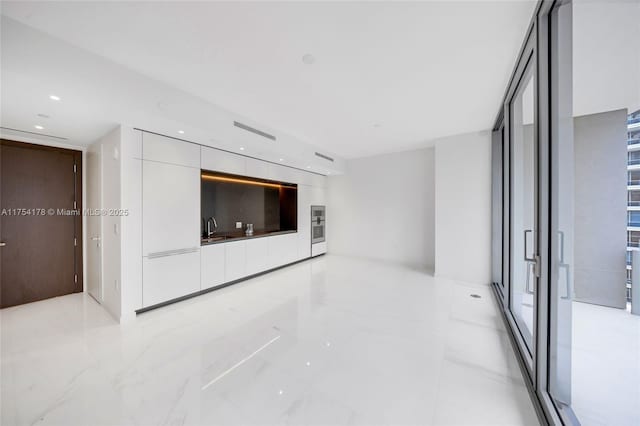 unfurnished living room featuring recessed lighting, visible vents, and a sink