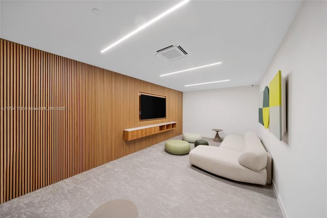 living room with carpet floors, wood walls, and visible vents