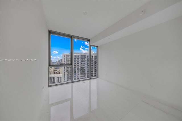 unfurnished room with floor to ceiling windows and a city view