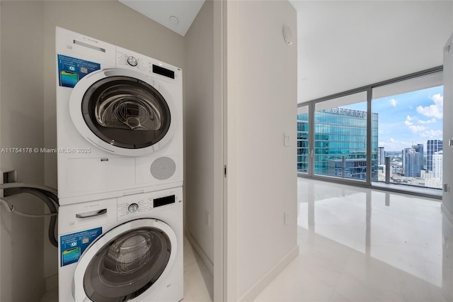 washroom featuring laundry area, a view of city, and stacked washer / dryer