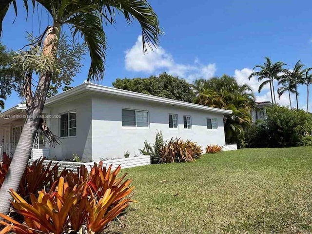 exterior space with a lawn and stucco siding