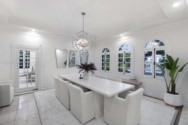 dining room with a tray ceiling, plenty of natural light, and crown molding