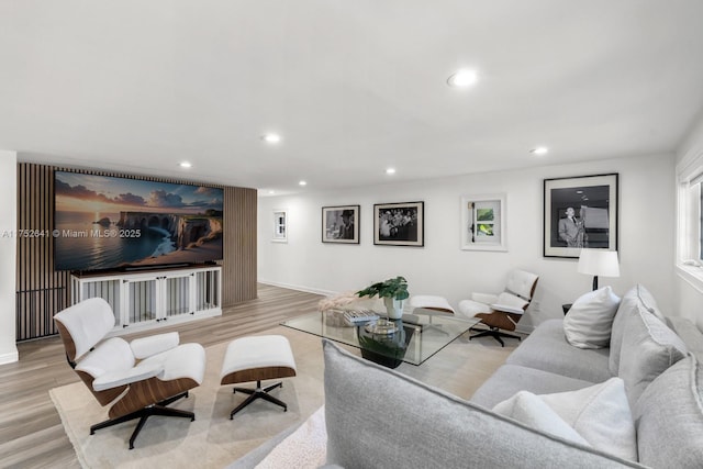 living area featuring baseboards, wood finished floors, and recessed lighting