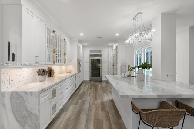 kitchen featuring white cabinetry, backsplash, and a kitchen breakfast bar