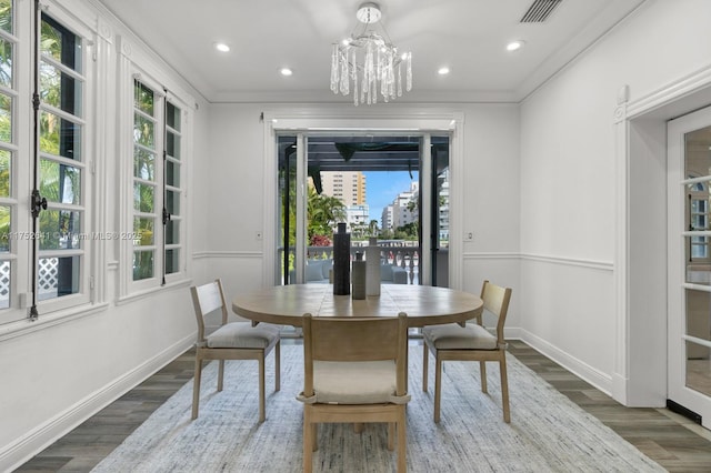 dining area with crown molding, dark wood-type flooring, visible vents, and baseboards