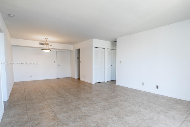 spare room featuring visible vents and baseboards