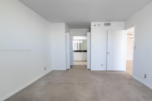 unfurnished bedroom with carpet floors, visible vents, and baseboards